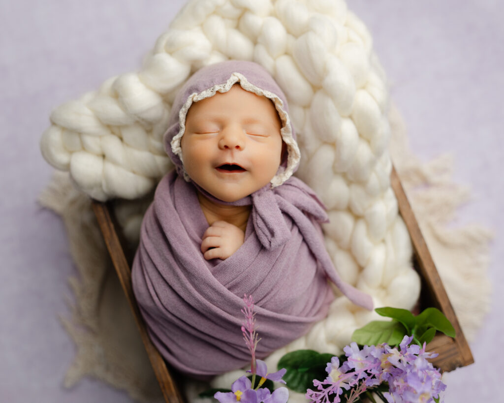 Timeless newborn photo outfit ideas with a swaddle and bonnet styled for studio photography