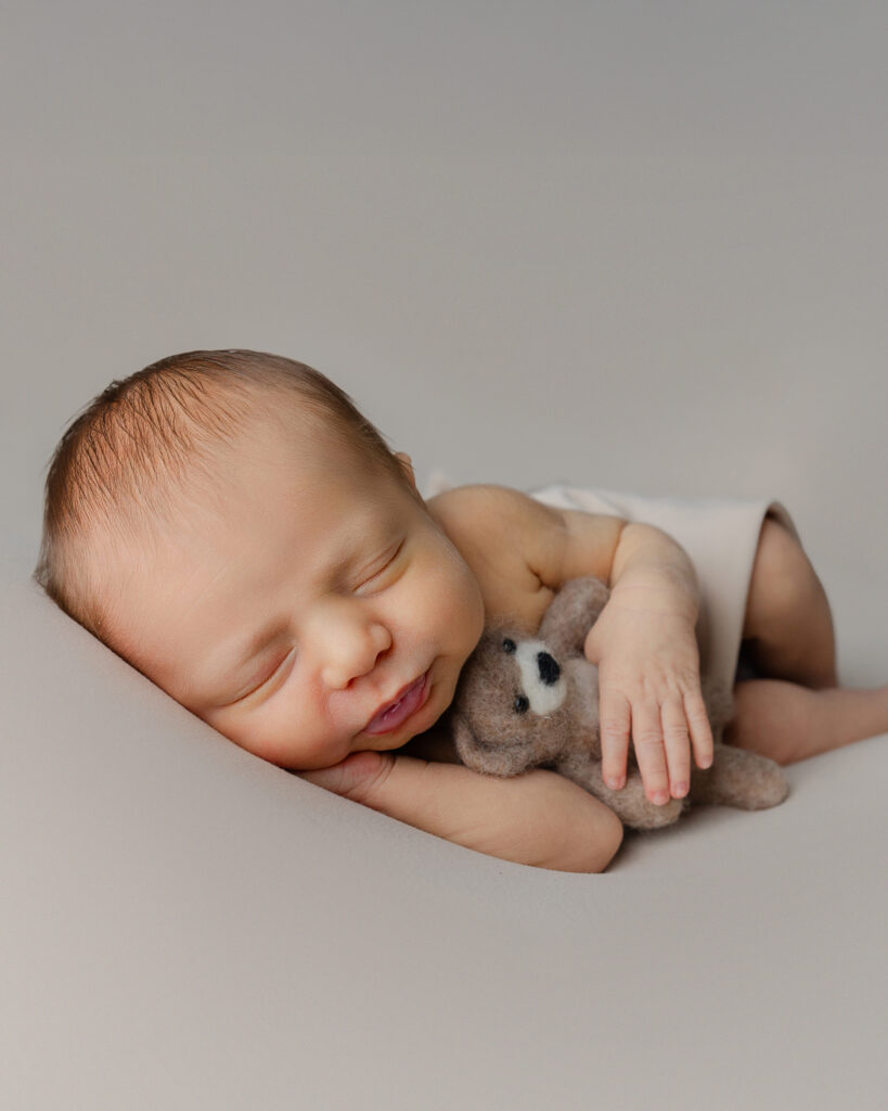 Newborn photo outfit ideas featuring a baby posed naturally with a simple wrap and soft neutral tones