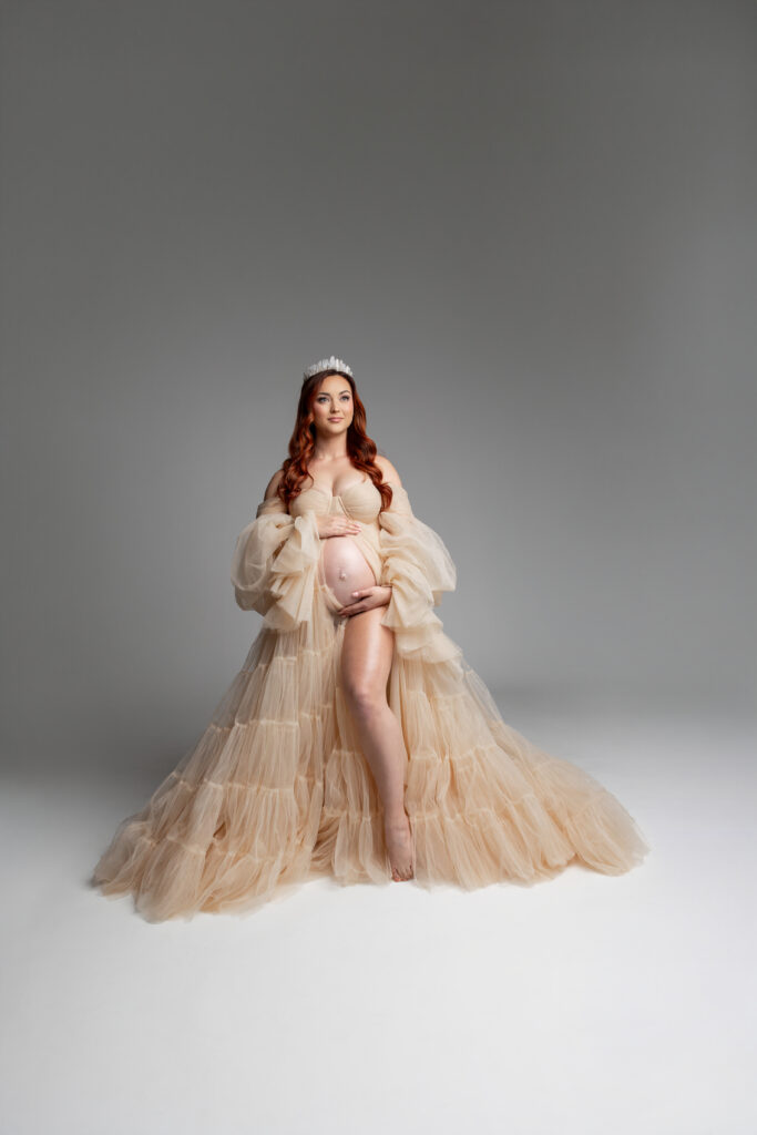 Timeless elegance meets maternal glow in this cream-colored gown and crown—celebrating the beauty of expecting life. Photograph by Inland Empire motherhood photographer Kaitlyn Dawn Photography.