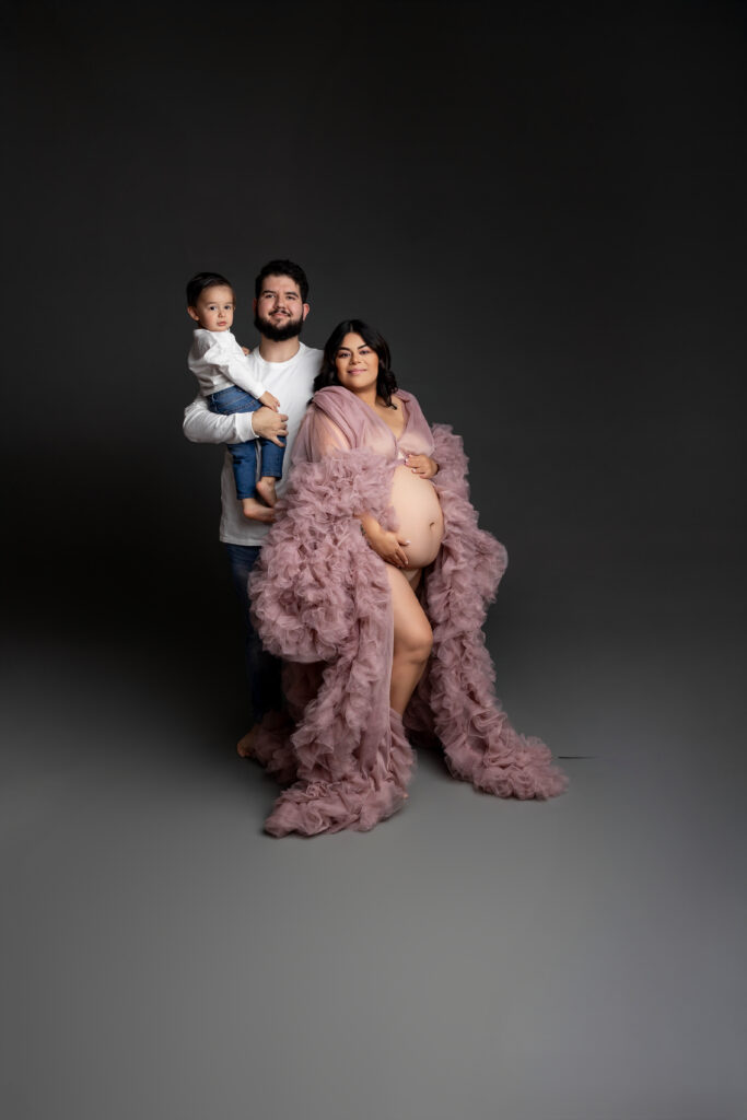 A beautiful family of three shares space and love as they await baby’s arrival together in one heartfelt frame. Photograph by Inland Empire motherhood photographer Kaitlyn Dawn Photography.