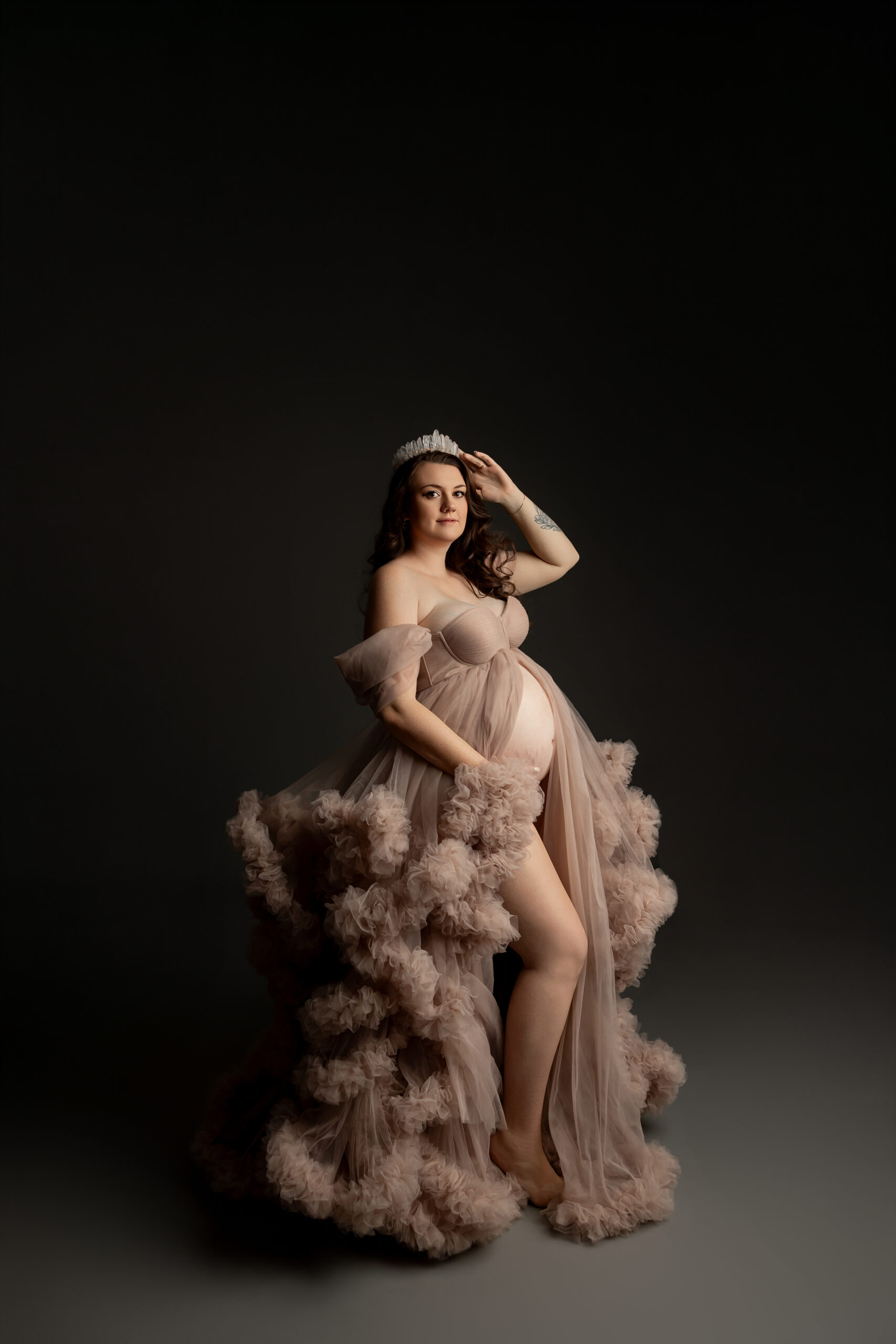 Elegant maternity portrait in a flowing blush gown during a studio session inspired by the best OB/GYNs near Beaumont CA. Photograph by Kaitlyn Dawn Photography.