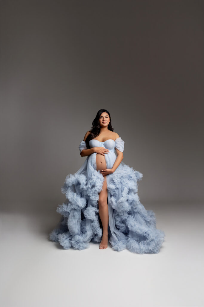A delicate sky-blue gown sets the stage for this maternity moment—simple, calm, and full of anticipation. Photograph by Inland Empire motherhood photographer Kaitlyn Dawn Photography.