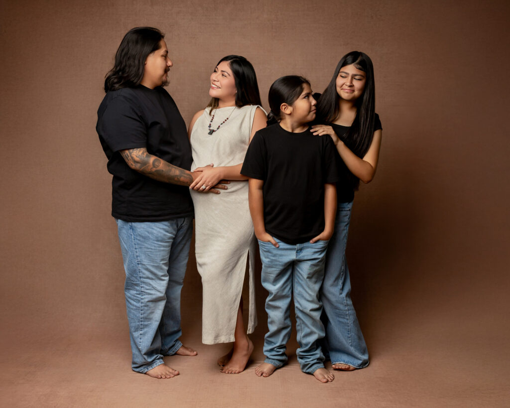 Studio portrait showing different photography styles for families with parents and children sharing natural connection against a warm brown backdrop.