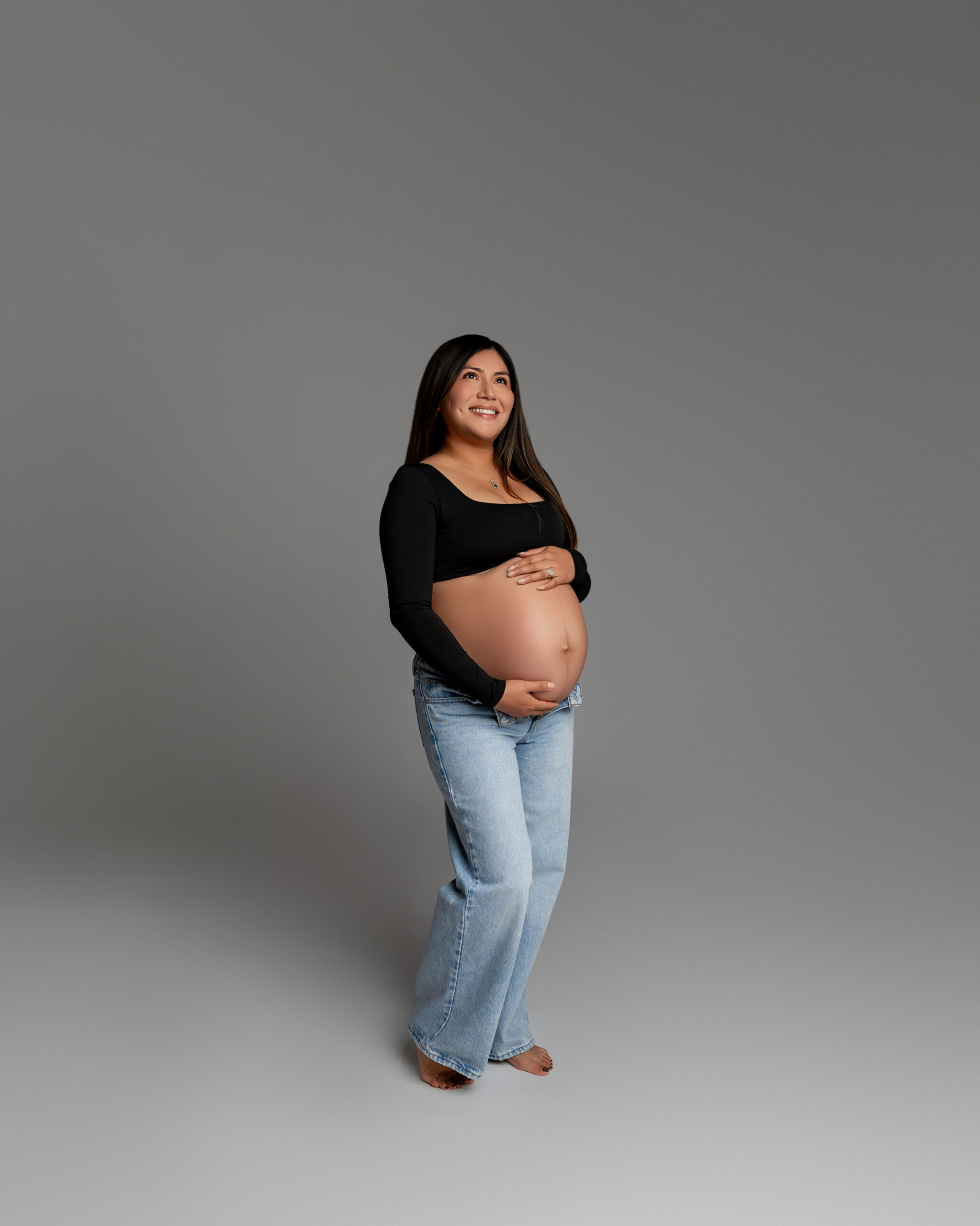 Casual maternity portrait showing what to wear during pregnancy with jeans and a fitted black top, photographed by Inland Empire maternity photographer Kaitlyn Dawn Photography.
