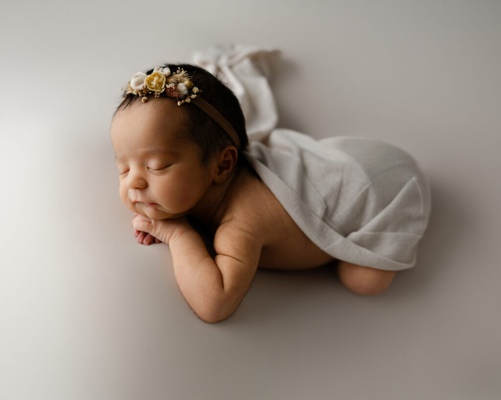 Side profile of a sleeping newborn draped in soft fabric, illustrating the calm moments that new mom support helps create for parents adjusting to life with a baby. — Kaitlyn Dawn Photography
