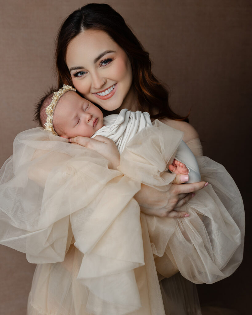 Mother holding her newborn during breastfeeding support in early motherhood, capturing a calm and connected postpartum moment.