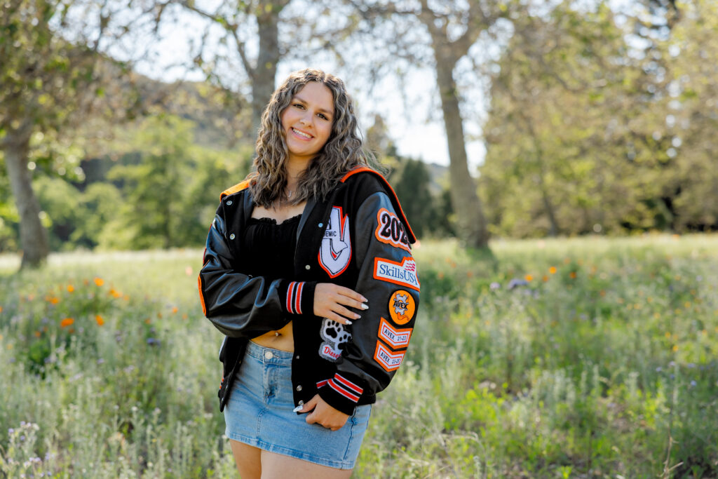 Yucaipa High School senior pictures featuring a graduate in her letterman jacket during an outdoor portrait session.