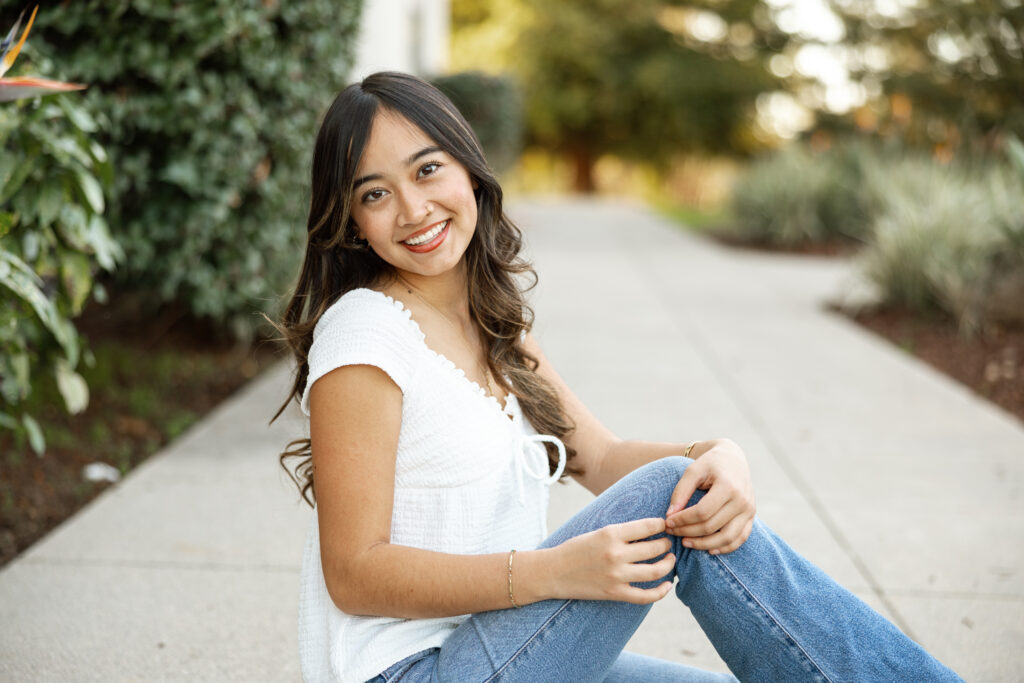 Casual senior photo prep inspiration featuring a Yucaipa senior in a white top and jeans during her outdoor session.