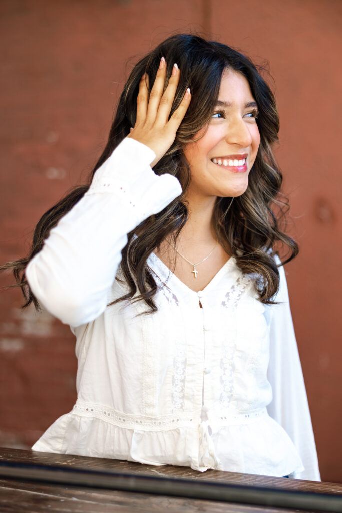 Senior girl in a candid shot showing how to pose in senior session.