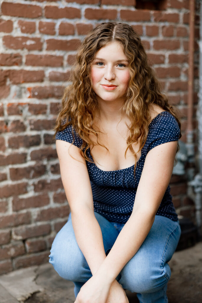 Casual senior portrait in a navy patterned top and jeans, showing an easy and comfortable outfit idea for senior pictures with Kaitlyn Dawn Photography.