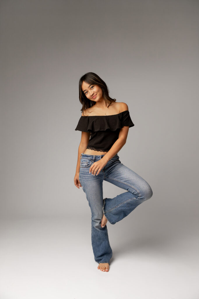 Full-body studio portrait of girl posing in jeans and black top in Redlands, by Kaitlyn Dawn Photography.