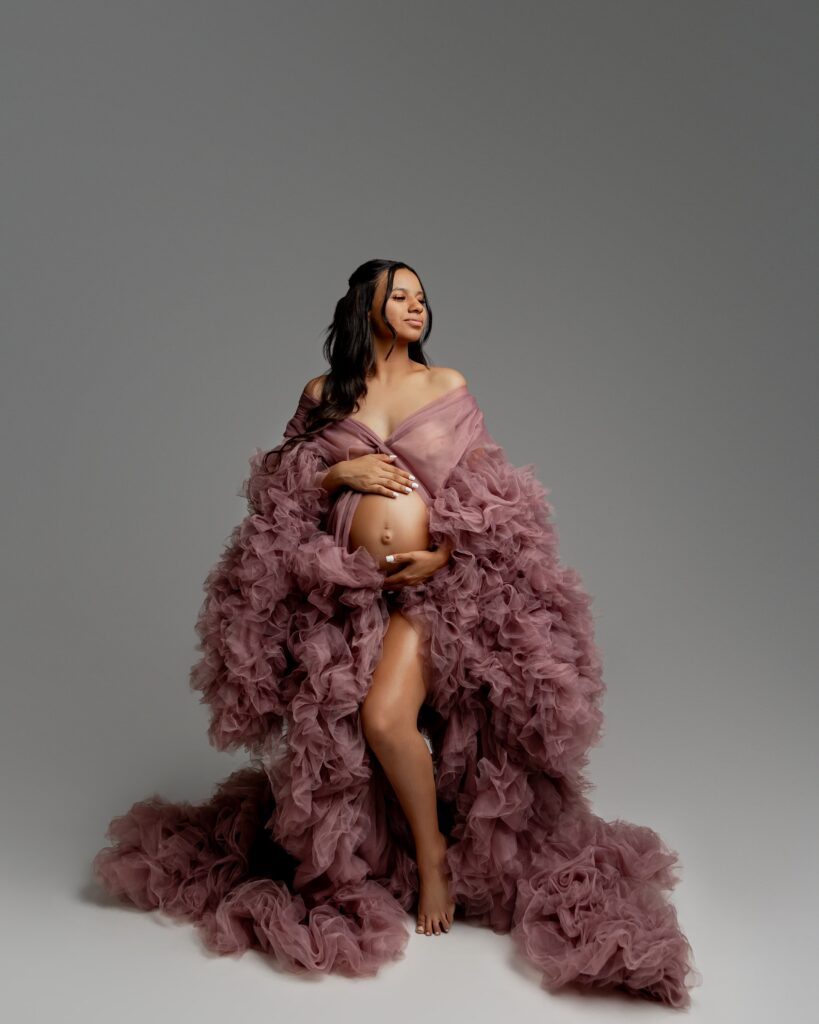 Elegant maternity portrait of expecting mother in flowing mauve gown during the hardest week of pregnancy, captured in a studio session by Inland Empire maternity photographer Kaitlyn Dawn Photography.
